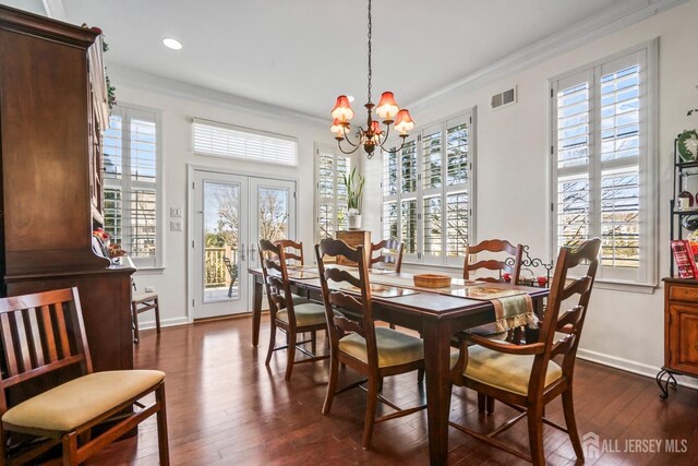 dining room featuring french doors, dark hardwood / wood-style flooring, a chandelier, and ornamental molding