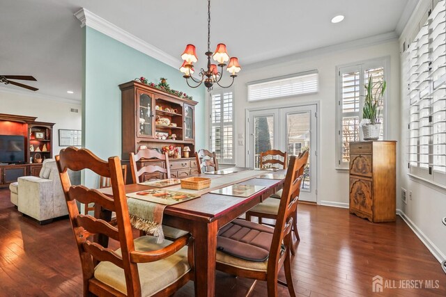 dining area featuring ceiling fan with notable chandelier, ornamental molding, and dark wood-type flooring