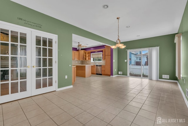 unfurnished living room featuring a healthy amount of sunlight, french doors, light tile patterned flooring, and visible vents