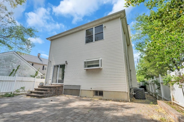 rear view of house featuring cooling unit, a fenced backyard, and a patio area