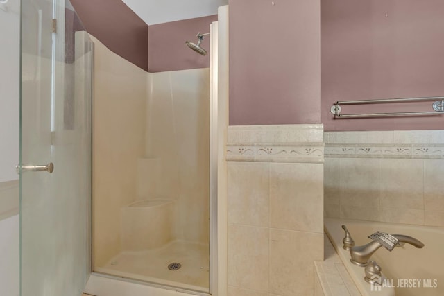 full bath with a shower stall and a garden tub