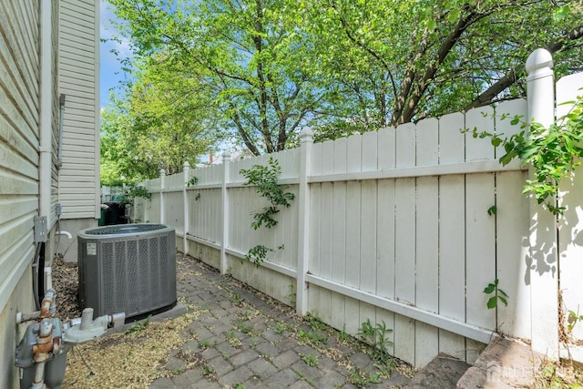 view of patio featuring central air condition unit and fence