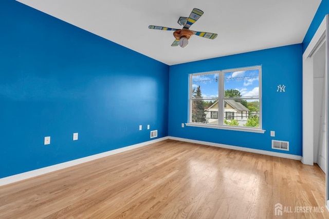 spare room featuring visible vents, baseboards, and wood finished floors