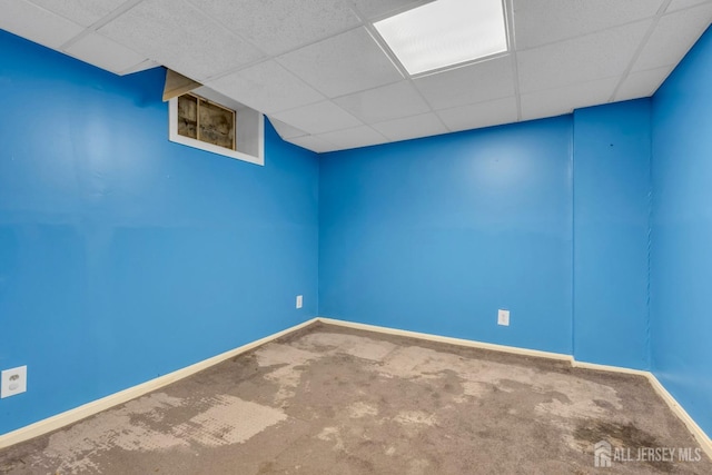unfurnished room with baseboards, carpet flooring, and a paneled ceiling