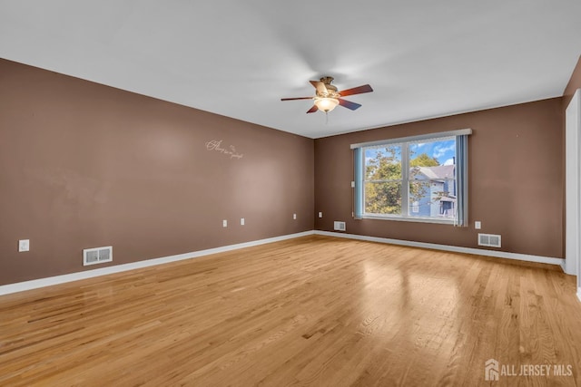 empty room with a ceiling fan, baseboards, visible vents, and light wood-type flooring