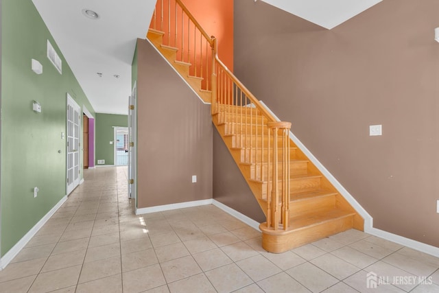 stairs featuring tile patterned floors, baseboards, and visible vents