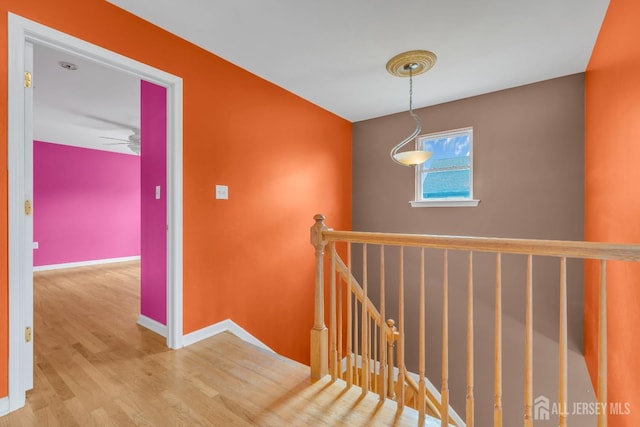 staircase featuring baseboards and wood finished floors