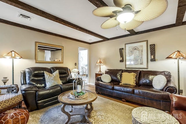 living area with visible vents, beamed ceiling, a ceiling fan, wood finished floors, and baseboards