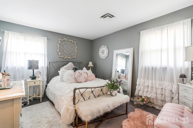 bedroom with visible vents and light carpet