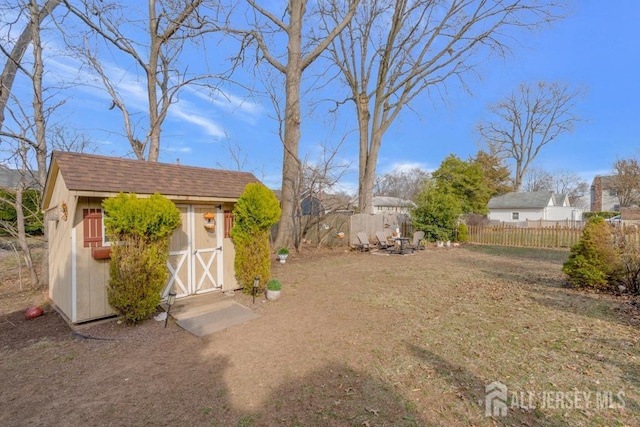 view of yard with a storage shed, an outdoor structure, and fence