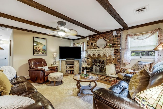 living area featuring beamed ceiling, a fireplace, visible vents, and ceiling fan