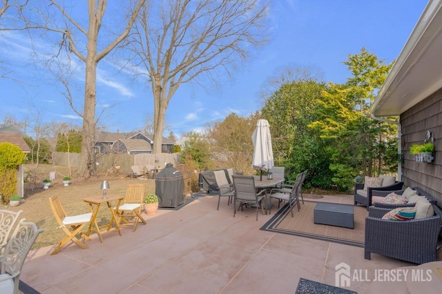 view of patio featuring outdoor dining area and fence