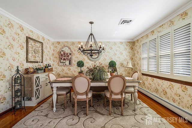 dining room featuring wallpapered walls, a baseboard heating unit, an inviting chandelier, and wood finished floors