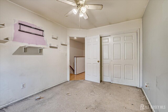 unfurnished bedroom with ceiling fan, a closet, and light carpet