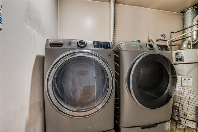 clothes washing area with washer and clothes dryer