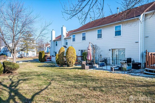 back of property with a lawn and a patio area