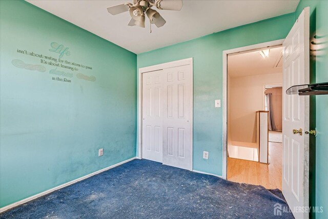 unfurnished bedroom featuring ceiling fan, a closet, and dark carpet