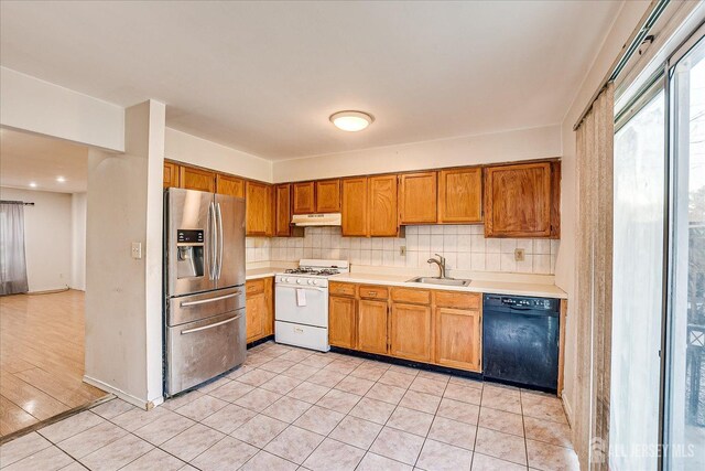 kitchen with stainless steel fridge with ice dispenser, gas range gas stove, backsplash, dishwasher, and sink