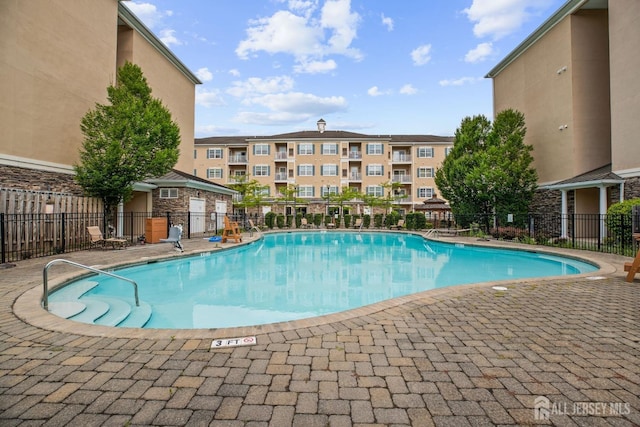 community pool featuring a patio area and fence