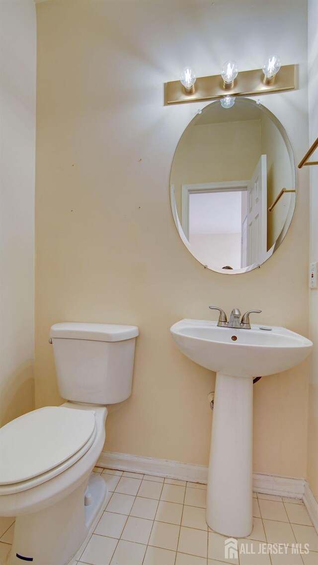 bathroom with tile patterned flooring, sink, and toilet