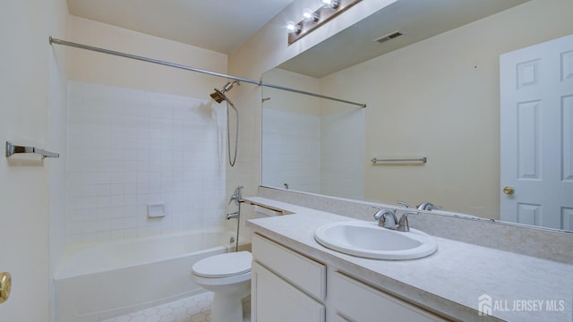 full bathroom featuring tile patterned flooring, vanity, tiled shower / bath, and toilet