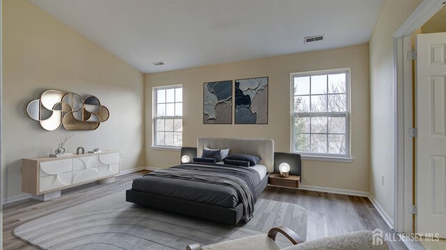 bedroom with vaulted ceiling and hardwood / wood-style floors