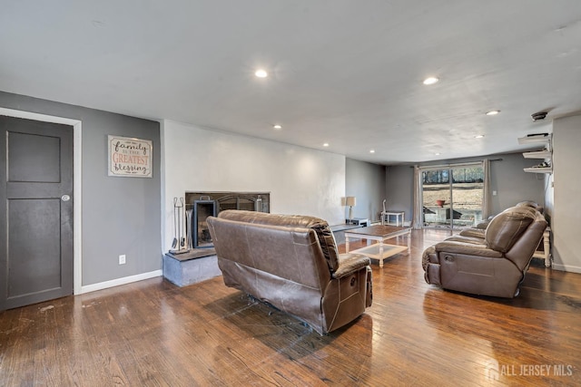 living area featuring baseboards, hardwood / wood-style floors, and recessed lighting