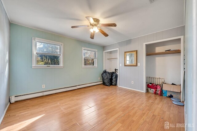 unfurnished bedroom with ceiling fan, a baseboard radiator, and light hardwood / wood-style floors