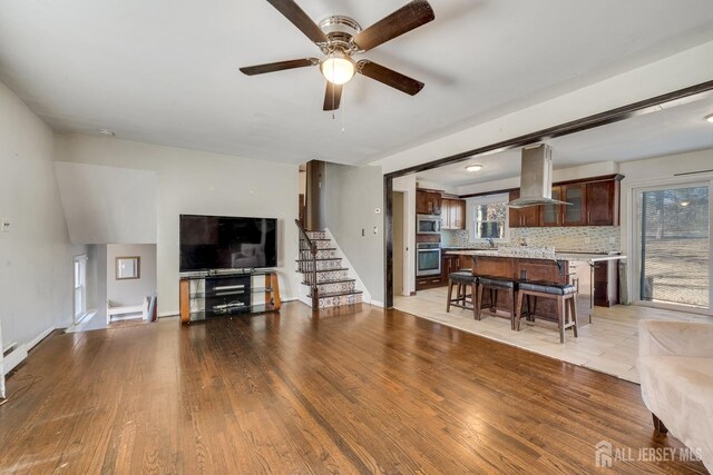 living room with sink, ceiling fan, and light wood-type flooring