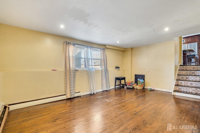 interior space featuring baseboards, wood finished floors, stairs, baseboard heating, and recessed lighting