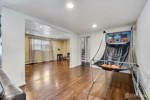 recreation room featuring a baseboard radiator and dark hardwood / wood-style floors