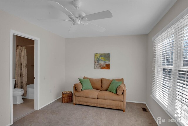 sitting room with light carpet, a wealth of natural light, and ceiling fan