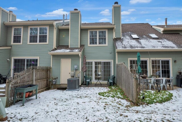 snow covered rear of property with central AC