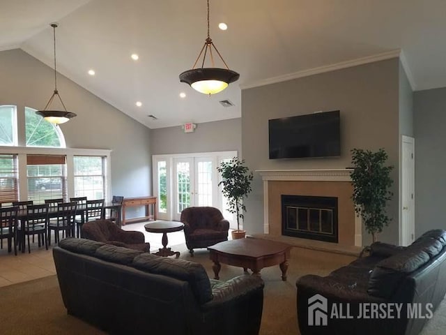 tiled living room with ornamental molding, high vaulted ceiling, and french doors