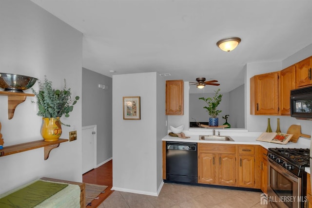 kitchen with sink, light tile patterned floors, black appliances, and ceiling fan