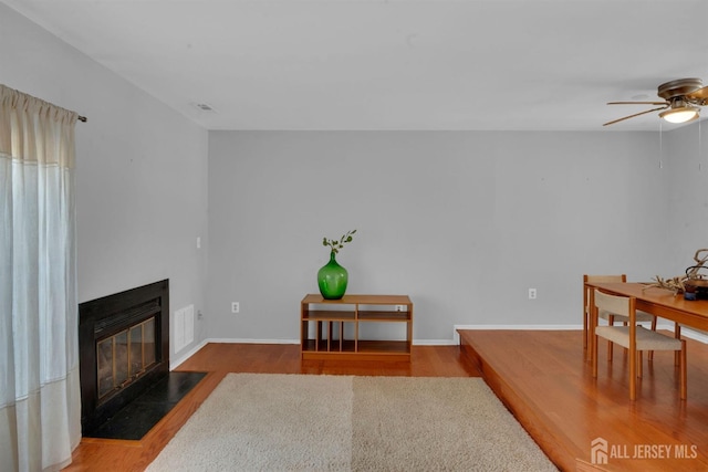 living room featuring dark hardwood / wood-style flooring and ceiling fan