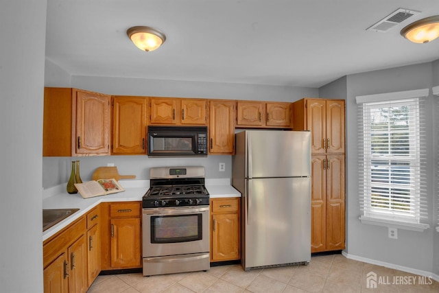 kitchen with stainless steel appliances, sink, and light tile patterned floors