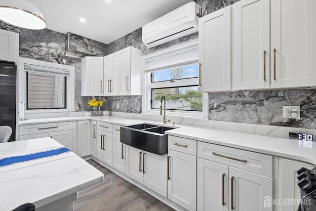 207 S Broadway, South Amboy, NJ 08879 - kitchen featuring a wall mounted air conditioner, a sink, white cabinets, wood finished floors, and backsplash