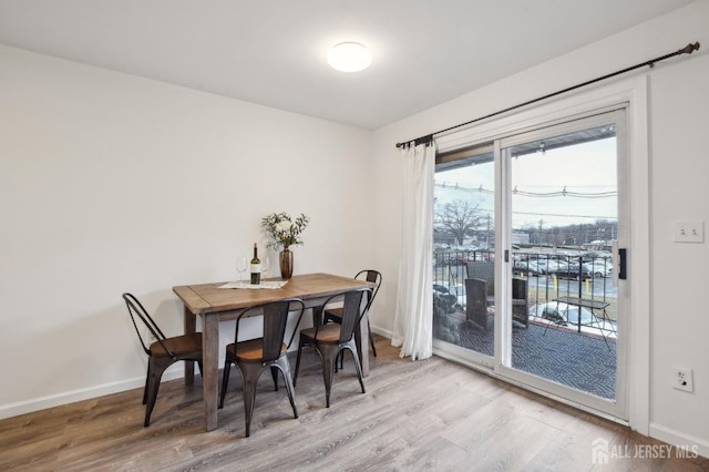 dining space with baseboards and wood finished floors