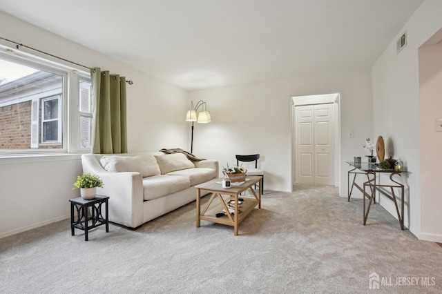 living room with carpet, visible vents, and baseboards