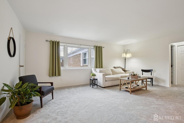 living area with light colored carpet and baseboards