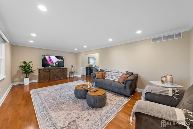 living area featuring ornamental molding, baseboards, recessed lighting, and wood finished floors