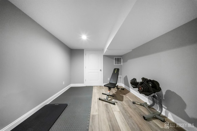 exercise room with wood finished floors and baseboards