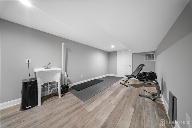 exercise room with wood finished floors, baseboards, and recessed lighting