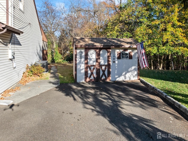 garage with central AC unit and a yard