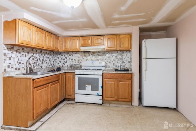 kitchen with light countertops, decorative backsplash, a sink, white appliances, and under cabinet range hood