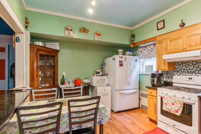 kitchen featuring ornamental molding, dark countertops, white appliances, and under cabinet range hood