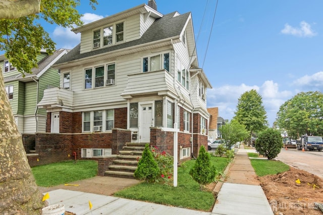 american foursquare style home with brick siding, a chimney, and a shingled roof