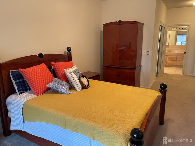 bedroom featuring ensuite bathroom and light carpet