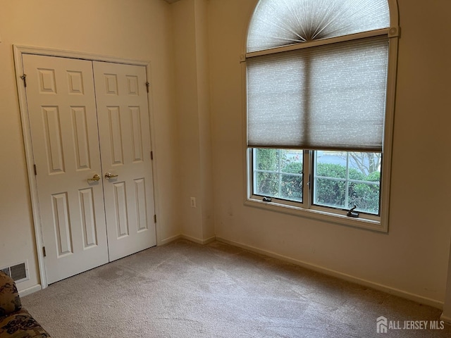 unfurnished bedroom featuring carpet floors and a closet